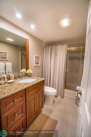 a spacious bathroom with a granite countertop sink a toilet and a shower