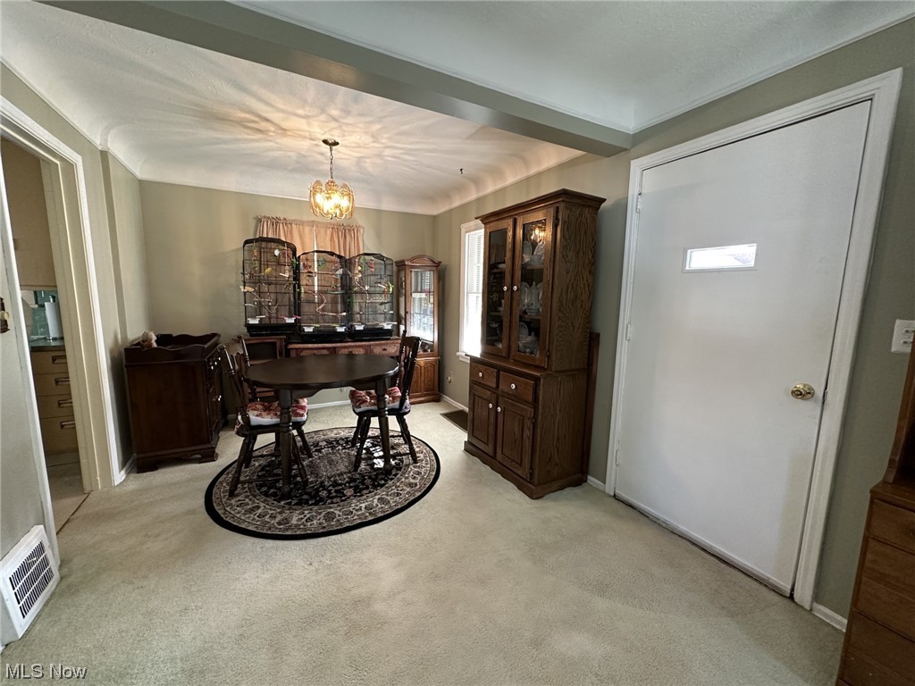14422 Alger Road Cleveland, OH 44111 - Photo 5 of 16 Dining space with a chandelier and light carpet