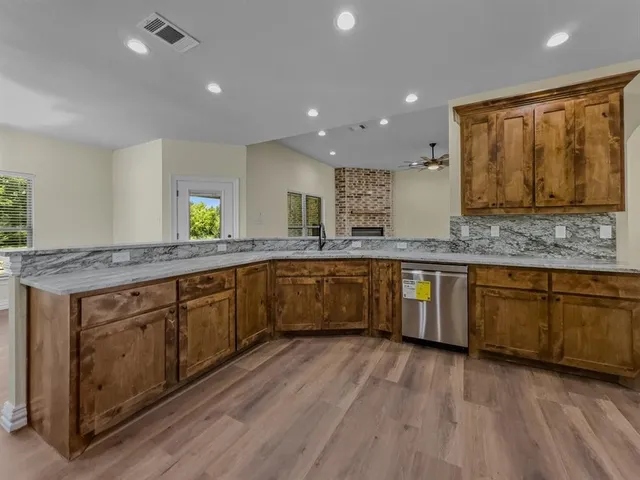 a kitchen with stainless steel appliances granite countertop a refrigerator a sink and a stove