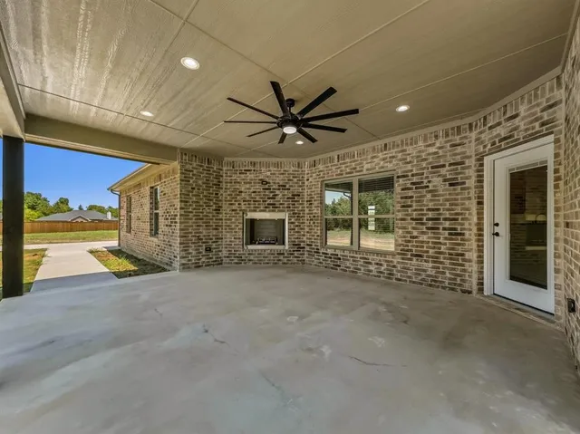 a view of a livingroom with a fireplace and a ceiling fan