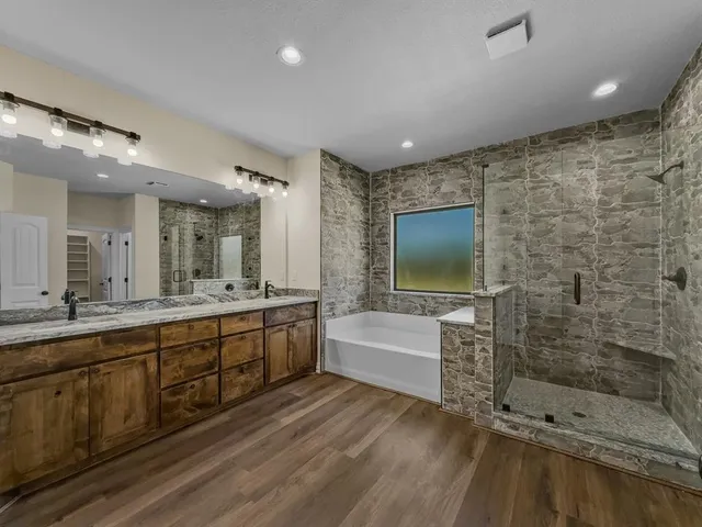 a spacious bathroom with a mirror a bathtub and a shower