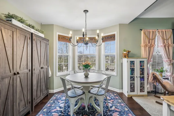 a dining room with furniture a chandelier and wooden floor