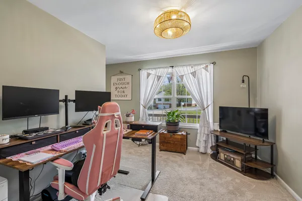 a living room with furniture a flat screen tv and a floor to ceiling window