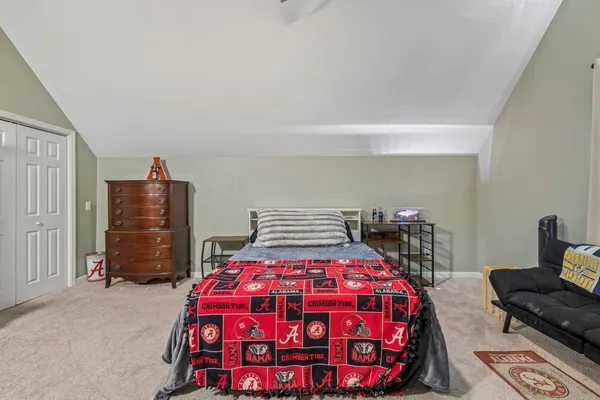 a bedroom with a bed a dresser and book shelf
