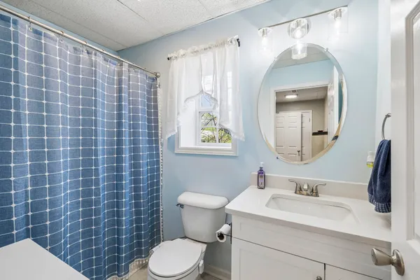a bathroom with a sink a toilet and a mirror