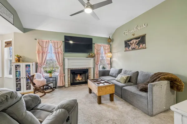 a living room with furniture a fireplace and a flat screen tv