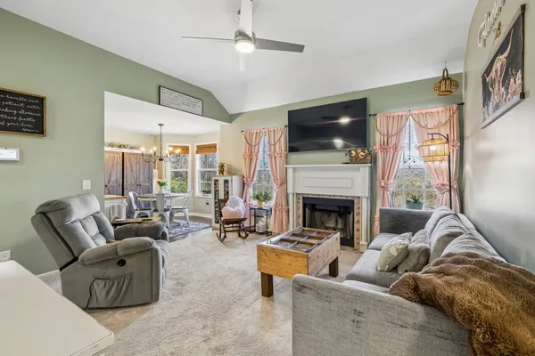 a living room with furniture a flat screen tv and a fireplace
