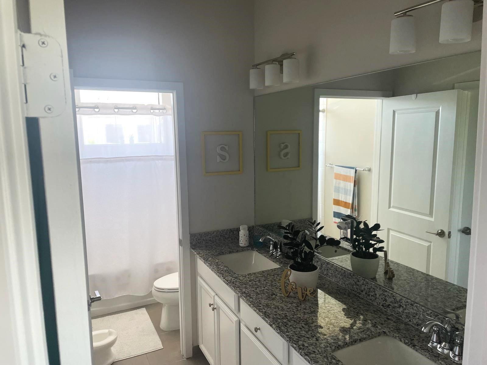 10957 Southwest 232nd Terrace Homestead, FL 33032 - Photo 9 of 11 a bathroom with a granite countertop sink a toilet and a mirror