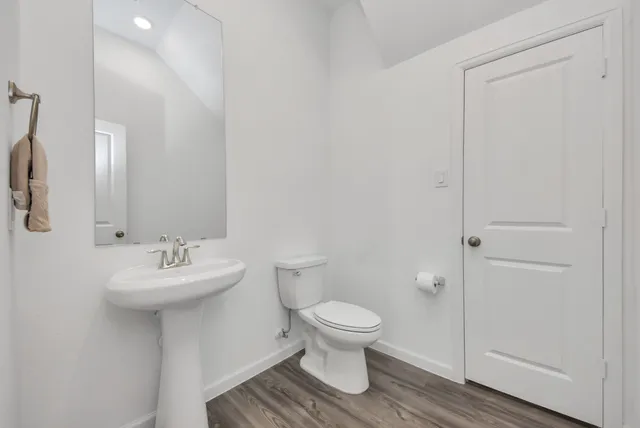 a kitchen with a dining table chairs and wooden floor