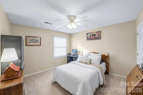 a bedroom with a bed and a lamp on dresser