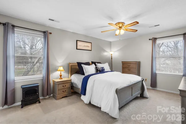 a spacious bedroom with a bed and a chandelier