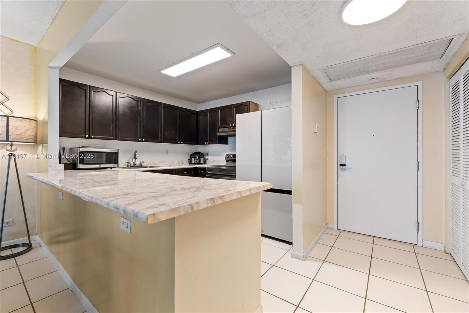 2301 Collins Avenue, Unit 802 Miami Beach, FL 33139 - Photo 8 of 26 a kitchen with stainless steel appliances a refrigerator sink and microwave