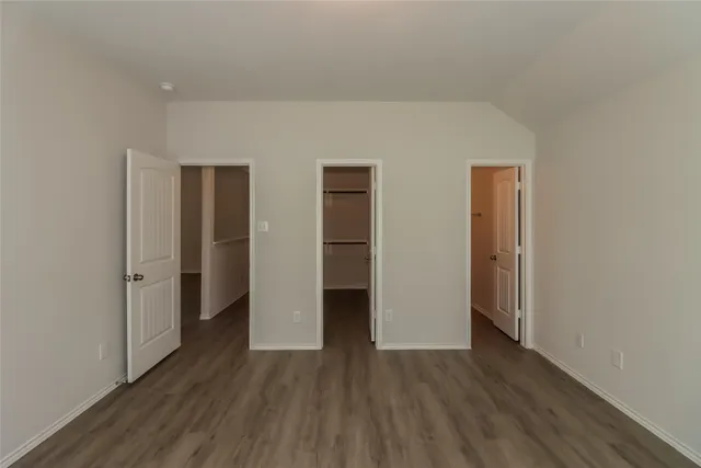 an empty room with wooden floor and closet