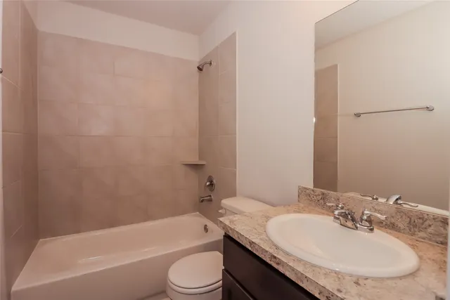 a bathroom with a granite countertop sink toilet and bathtub