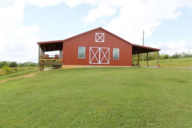 a sign board with lawn chairs and a table under an umbrella