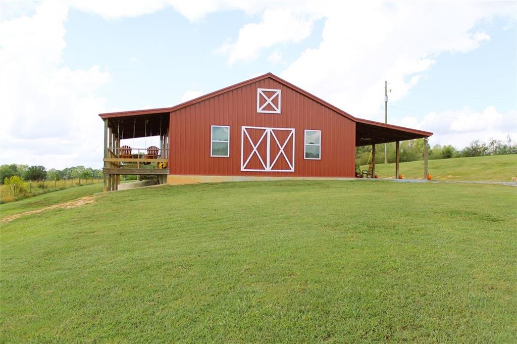 a sign board with lawn chairs and a table under an umbrella
