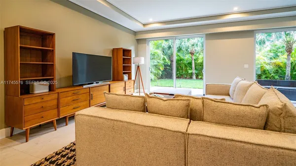 a living room with furniture and large windows