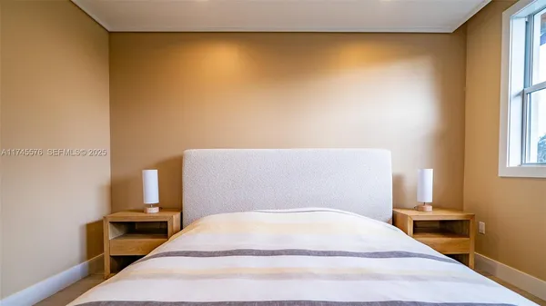 a view of a room with a window and a bed