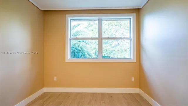 a view of a room with wooden floor and a ceiling fan