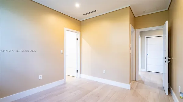 a view of a room with wooden floor and a ceiling fan