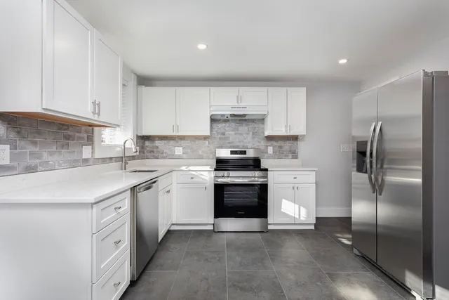 a kitchen with stainless steel appliances granite countertop a refrigerator sink and cabinets