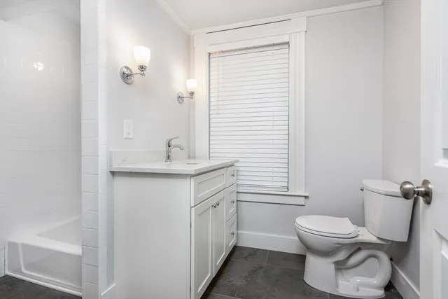 a bathroom with a toilet a sink and a window