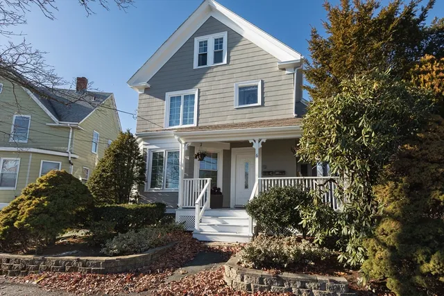 a front view of a house with a yard and potted plants
