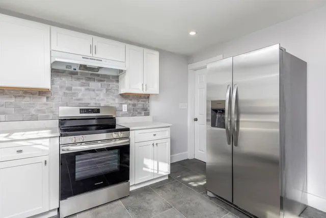 a kitchen with a stove top oven and refrigerator
