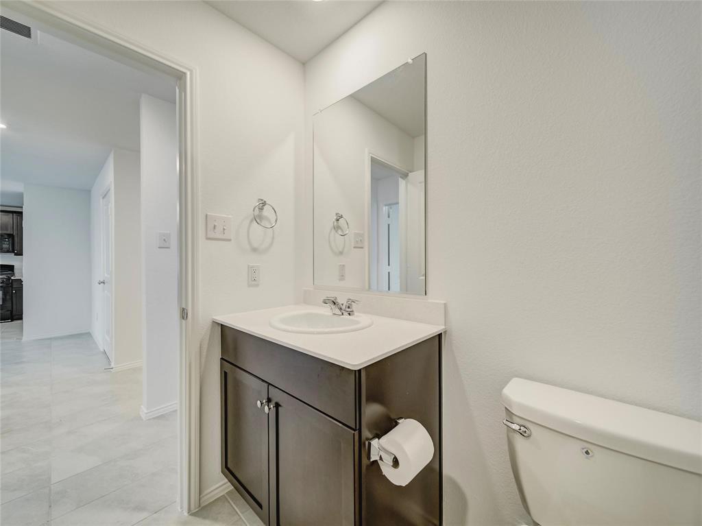 357 Sun Bluff Road Fort Worth, TX 76052 - Photo 14 of 35 Powder room with a dark wood-finish vanity, white countertop, and integrated sink