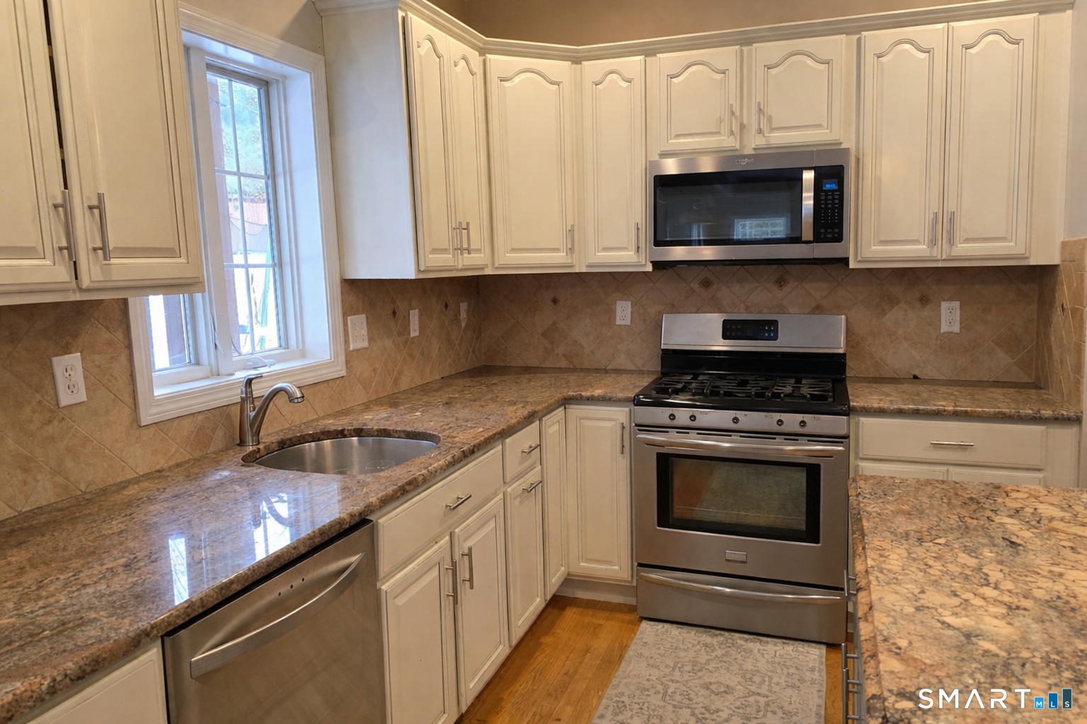83 Robin Street Bristol, CT 06010 - Photo 6 of 9 a kitchen with stainless steel appliances granite countertop a sink a stove and microwave