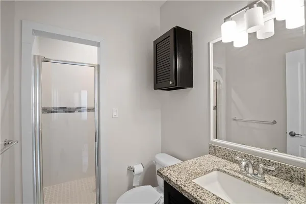 a bathroom with a granite countertop sink toilet and shower