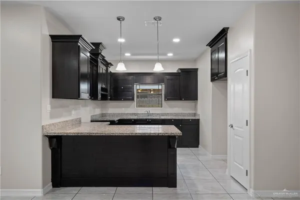 a kitchen with stainless steel appliances granite countertop a sink and a refrigerator
