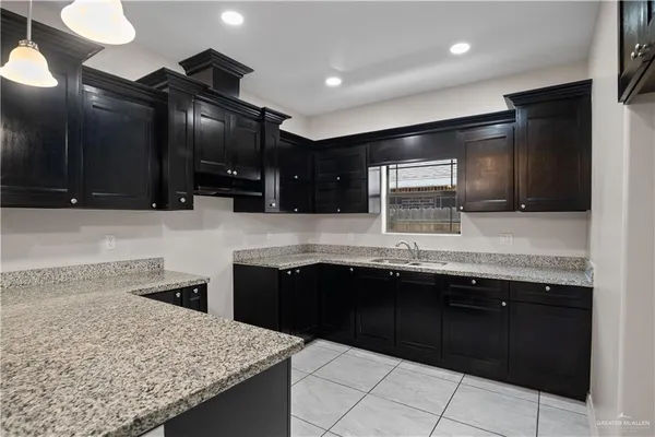 a kitchen with granite countertop sink stove and cabinets