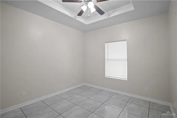 an empty room with windows and ceiling fan