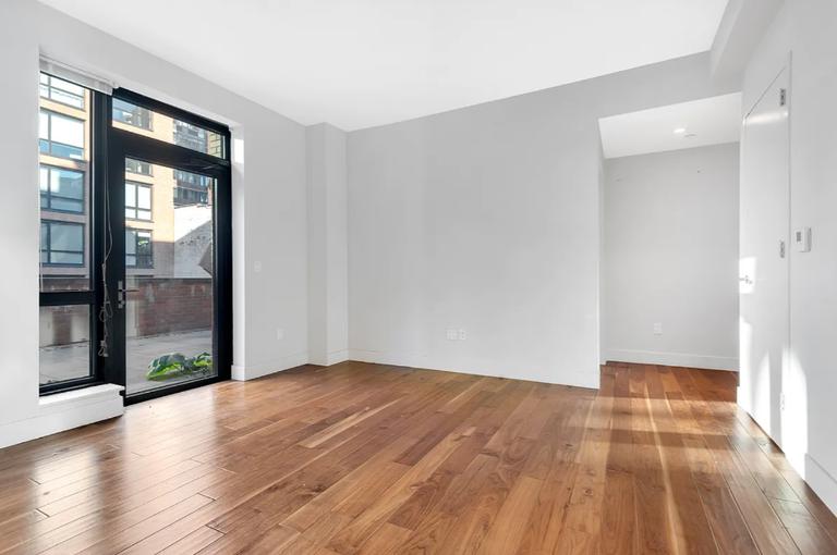 537 West 27th Street, Unit 2D Manhattan, NY 10001 - Photo 5 of 14 an empty room with wooden floor and windows