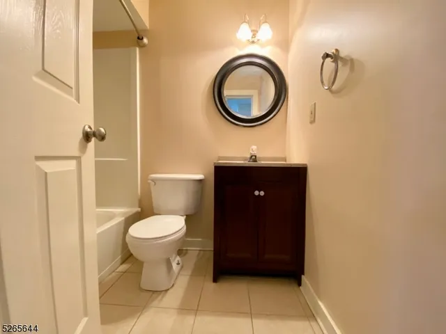 a bathroom with a granite countertop toilet and a sink