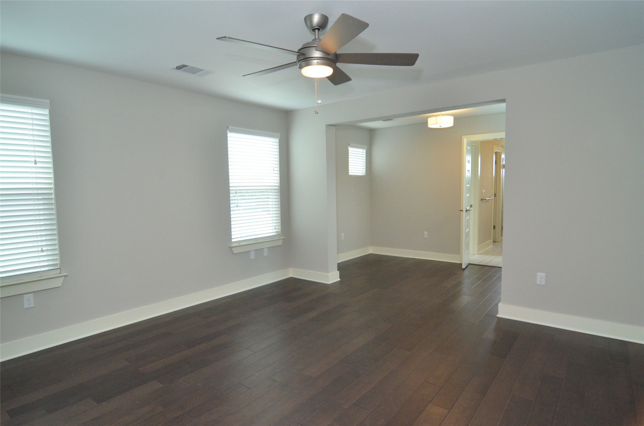1916 Cleese Drive Austin, TX 78741 - Photo 27 of 36 Rich hardwood flooring stretches across this naturally illuminated bedroom, offering a serene retreat.