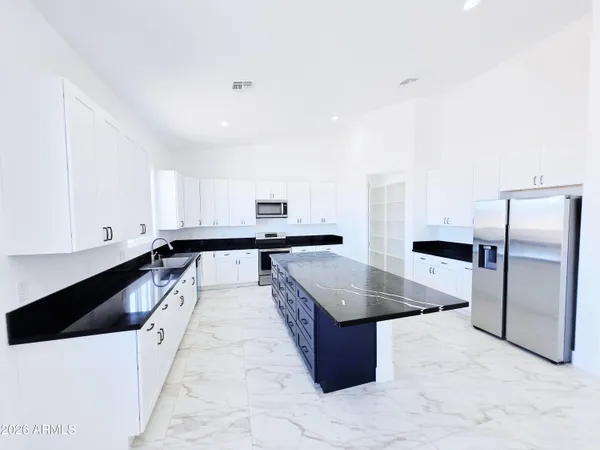 a view of a kitchen with wooden floor and white walls