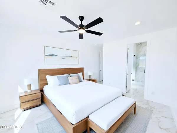 a bedroom with a bed and a painting on the wall