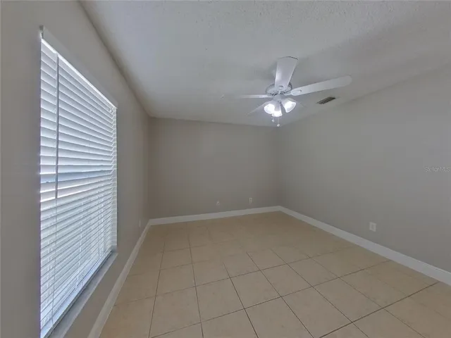 an empty room with closet and a ceiling fan