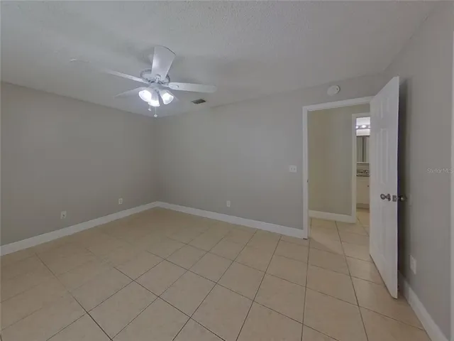 an empty room with closet and a ceiling fan
