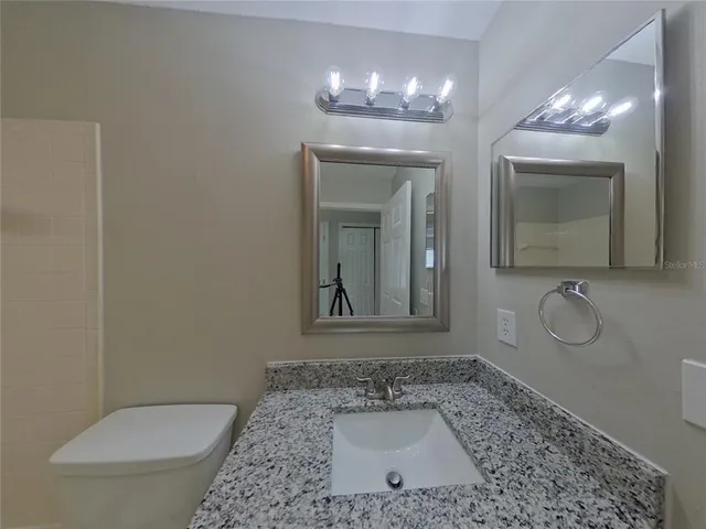 a bathroom with a toilet a sink and mirror