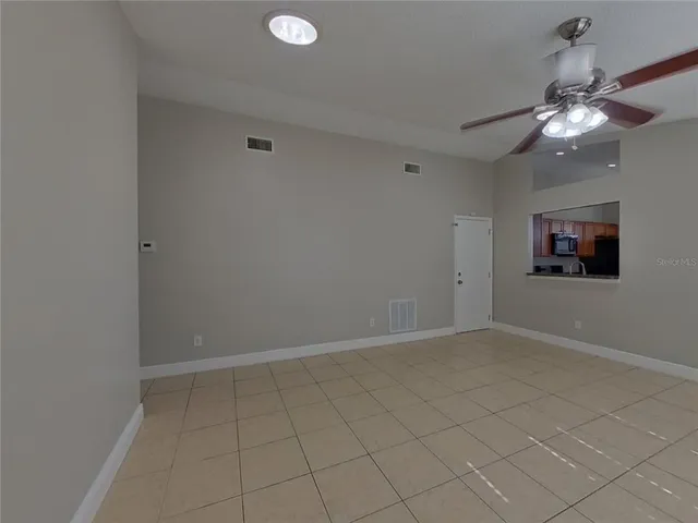 an empty room with chandelier fan