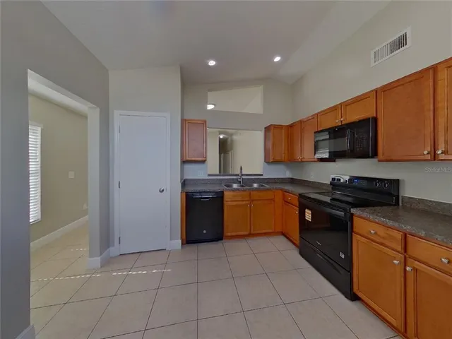 a large kitchen with granite countertop a stove a sink dishwasher and a refrigerator