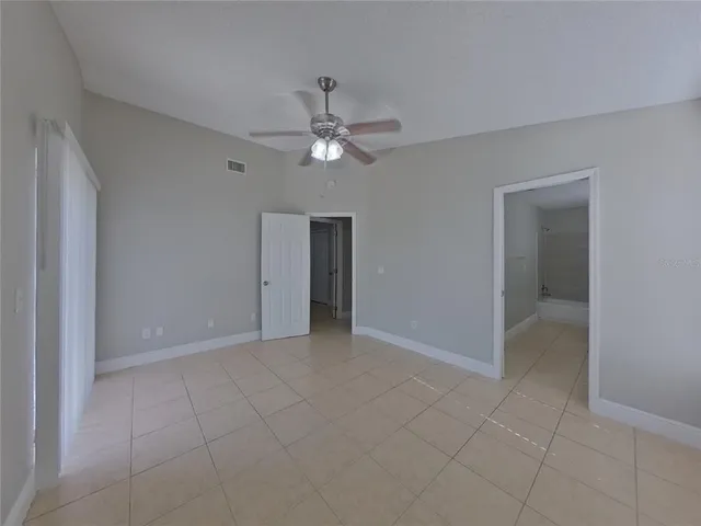 a view of an empty room with a ceiling fan
