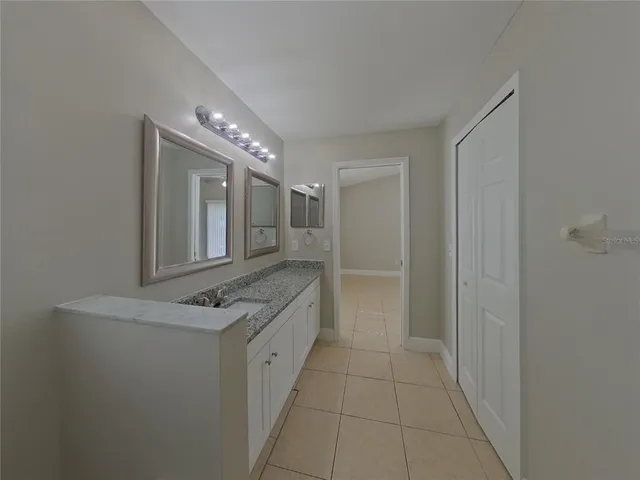 a bathroom with a granite countertop sink a large mirror and a shower