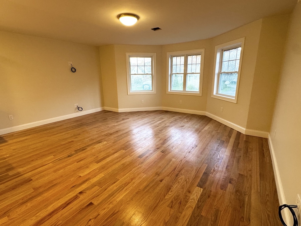 78 Arlington Street, Unit 1 Taunton, MA 02780 - Photo 5 of 28 a view of an empty room with wooden floor and a window