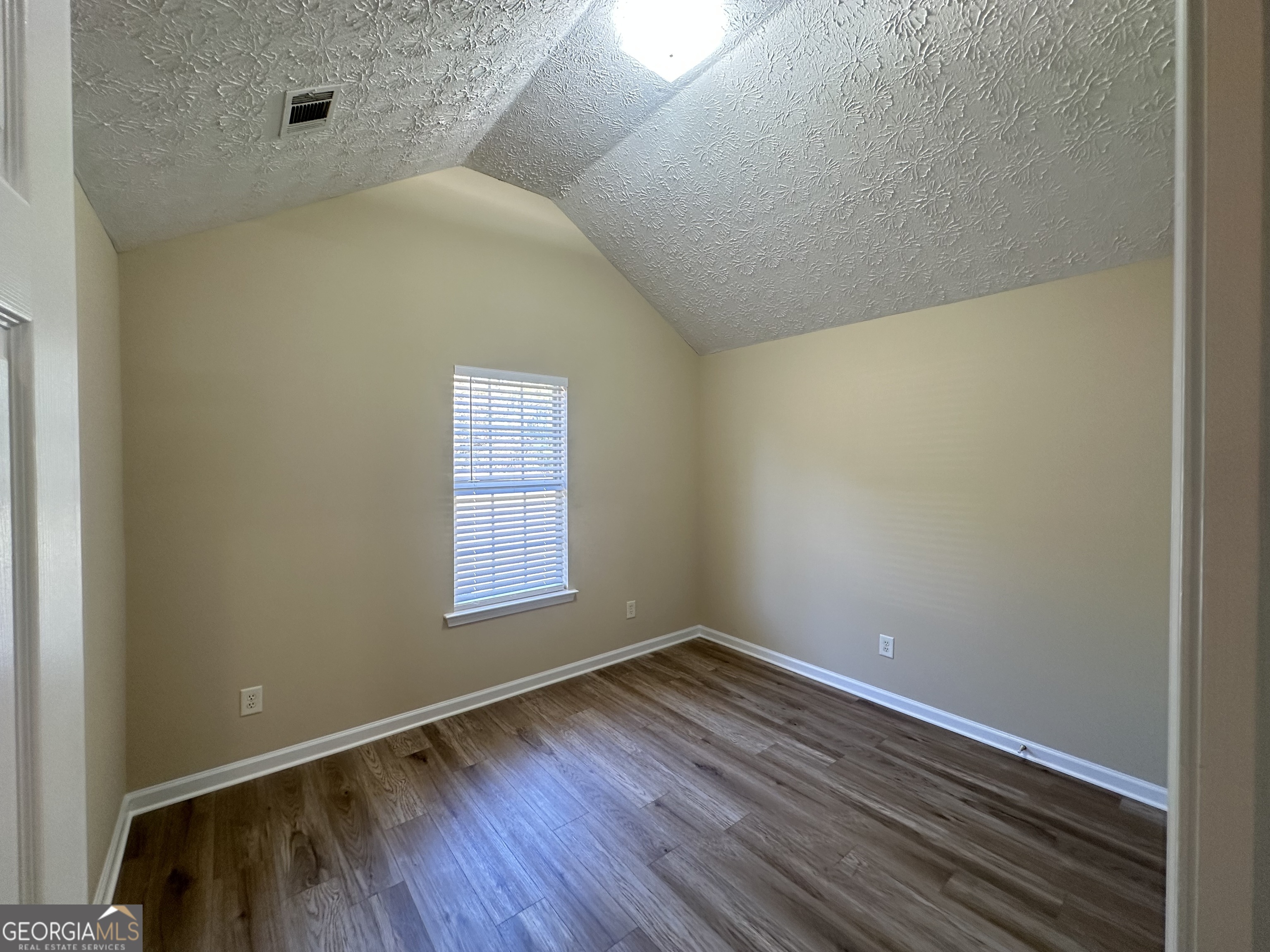 3860 Cedar Rock Road Woodbury, GA 30293 - Photo 11 of 14 a view of an empty room with wooden floor and a window