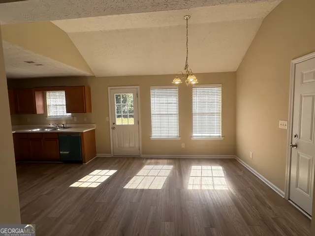 a view of kitchen and hall with wooden floor