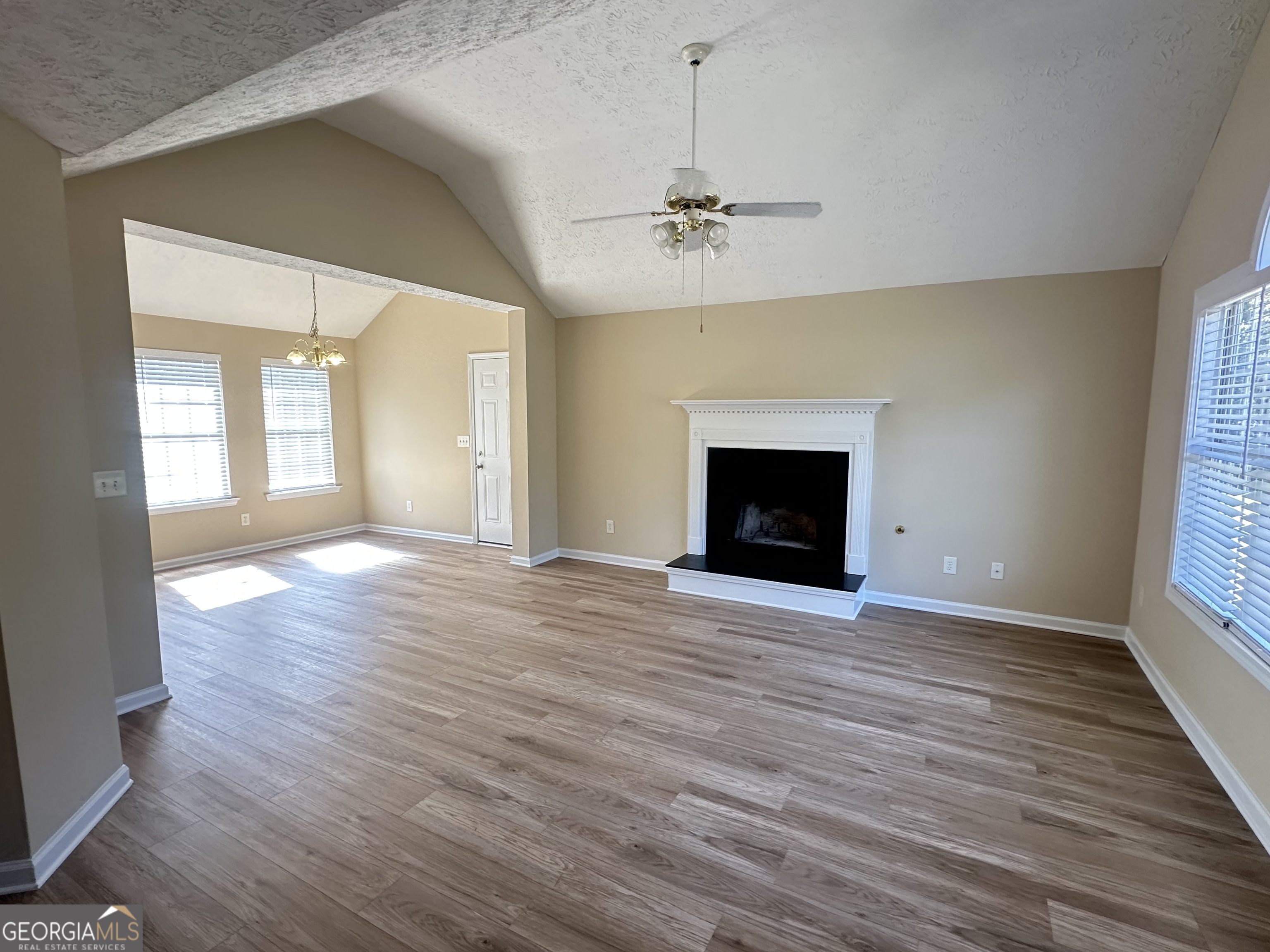 3860 Cedar Rock Road Woodbury, GA 30293 - Photo 4 of 14 an empty room with wooden floor fireplace and windows